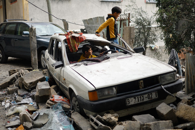 Palestinian children sit inside a damaged car, next to the rubble of a house destroyed in Israeli strikes during the conflict, amid the temporary truce between Hamas and Israel, at Khan Younis refugee camp in Gaza on Nov. 27, 2023. (Reuters)