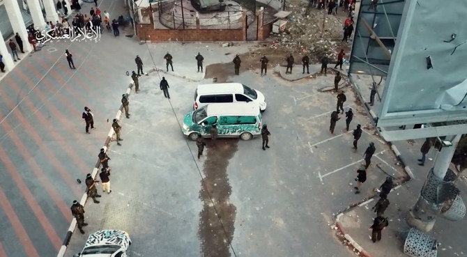 Hamas militants stand by vehicles as they hand over hostages who were abducted during the October 7 attack on Israel to members of the International Committee of the Red Cross, as part of a hostages-prisoners swap deal between Hamas and Israel amid a temporary truce, in an unknown location in the Gaza Strip, in this screengrab taken from video released November 26, 2023. (Reuters)