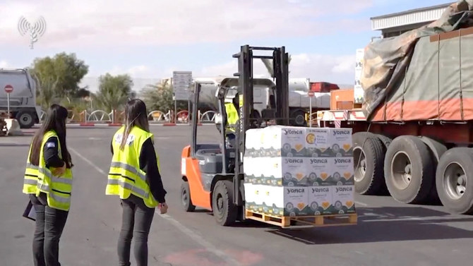 Workers load humanitarian aid onto trucks leaving for Gaza, during a temporary truce between the Palestinian Islamist group Hamas and Israel, at Nitzana crossing, Israel November 28, 2023, in this screengrab from a handout video. (Reuters)