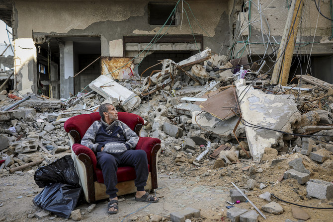 A Palestinian man sits in an armchair outside a destroyed building in Gaza City on Nov. 29, 2023, the sixth day of the temporary ceasefire between Hamas and Israel. (AP)