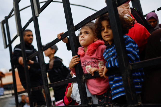 Children look on as Palestinians gather at the site of an Israeli strike, in the southern Gaza Strip. (Reuters)