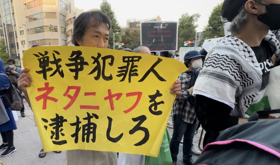 A Japanese activist carries a banner with a slogan that says: