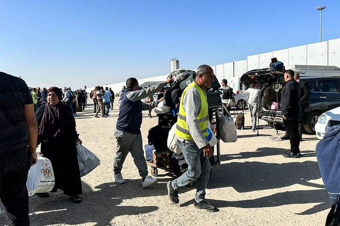 Passengers returning to the Gaza Strip arrive at the Egyptian side of the Rafah border crossing in the north eastern Sinai province, hours after the start of a four-day truce in battles between Israel and Hamas, on Nov. 24, 2023. (AFP)