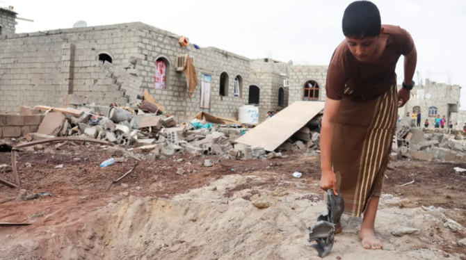 A Yemeni boy picks up shrapnel after a Houthi missile attack in Marib, Yemen, Oct. 3, 2021. (Reuters)