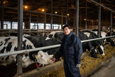 This picture taken on December 6, 2023 shows dairy farmer Eiji Mizushita speaking to the media at the farm in Taiki of Hokkaido Prefecture. (AFP)