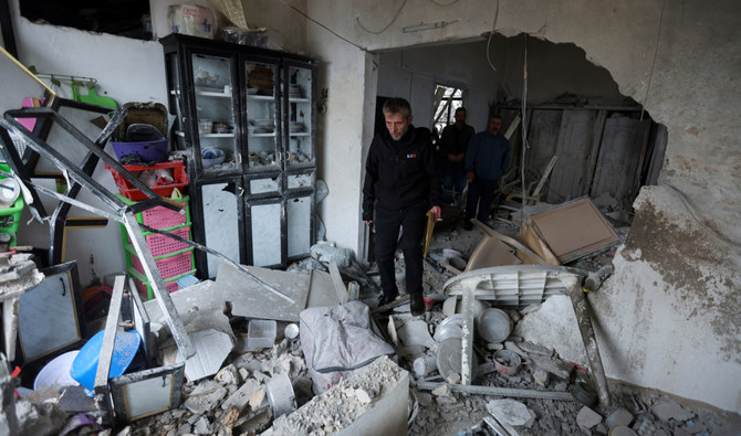 Qazim Jaber, mayor of the village of Mhaibib, inspects the damage inside a house that was damaged during Israeli shelling in recent weeks prior to a truce taking hold between Hamas and Israel that has informally extended to southern Lebanon, in Mhaibib village, near the border with Israel, southern Lebanon, November 28, 2023. (Reuters/File)