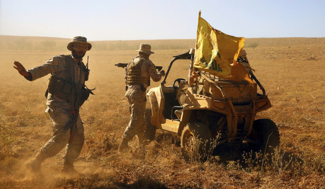 Hezbollah fighters stand near a four-wheel motorcycle positioned at the site where clashes erupted between Hezbollah and al-Qaida-linked fighters in Wadi al-Kheil or al-Kheil Valley on the Lebanon-Syria border, July 29, 2017. (AP)