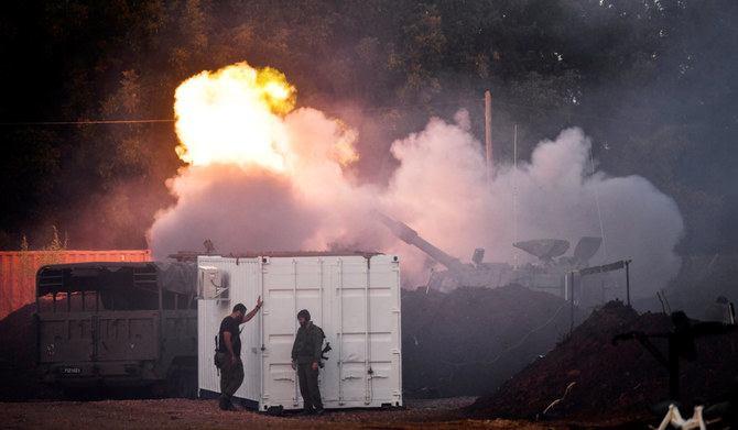 Israeli soldiers stand by, as a mobile artillery unit fires on the Israeli side of the Israel-Lebanon border December 2, 2023. (REUTERS)