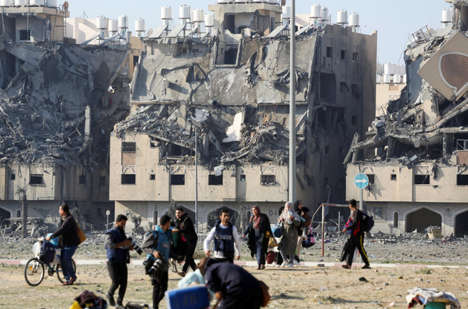 Buildings lie in ruin as Palestinians carry their belongings following Israeli strikes on residential buildings at the Qatari-funded Hamad City, amid the ongoing conflict between Israel and the Palestinian Islamist group Hamas, in Khan Younis in the southern Gaza Strip December 2, 2023. (REUTERS)