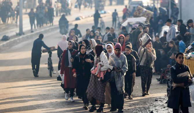 Palestinians walk toward safer areas following the resumption of Israeli strikes on Rafah in the southern Gaza Strip on December 1, 2023, after the expiration of a seven-day truce between Israel and Hamas militants. (AFP)
