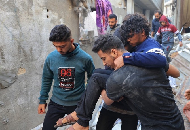 An injured man is carried away after a house was hit by Israeli bombing in Khan Yunis in the southern Gaza Strip on December 3, 2023. (AFP)