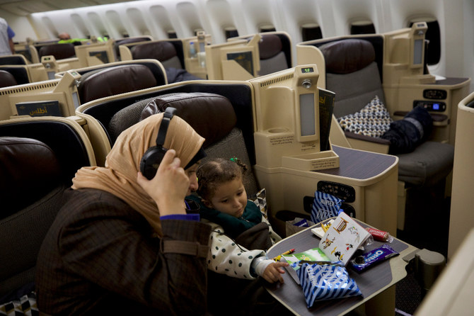 Three-year-old Karma Al-Khateeb was unable to ignore her pain despite attempts by her mother Douaa Abu Rahma and a cabin crew member to distract her with a coloring book and crayons. (AN Photo: Mohammed Fawzy)