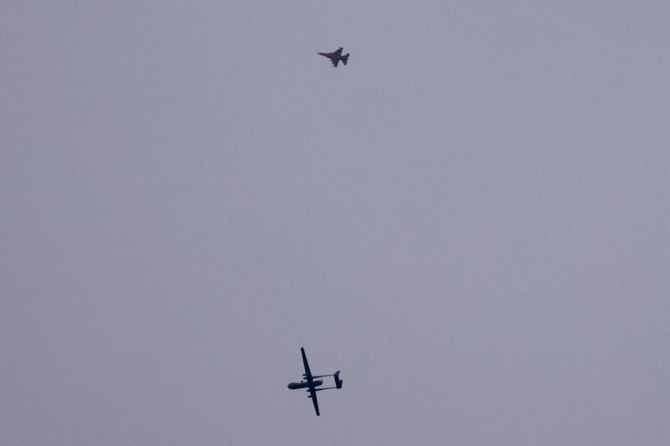 An Israeli unmanned aerial vehicle (UAV or drone) and a fighter jet (top) fly over the border with the Gaza Strip in southern Israel on November 17, 2023. (File/AFP)