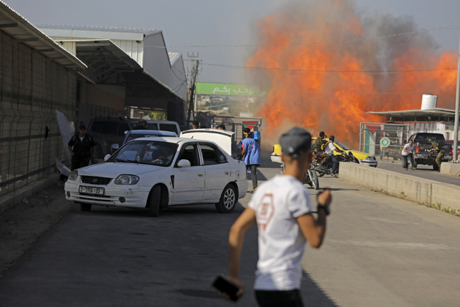 Palestinians and militants from the Ezzedine al-Qassam Brigades run towards the Erez crossing between Israel and the northern Gaza Strip on October 7, 2023. (AFP/File)