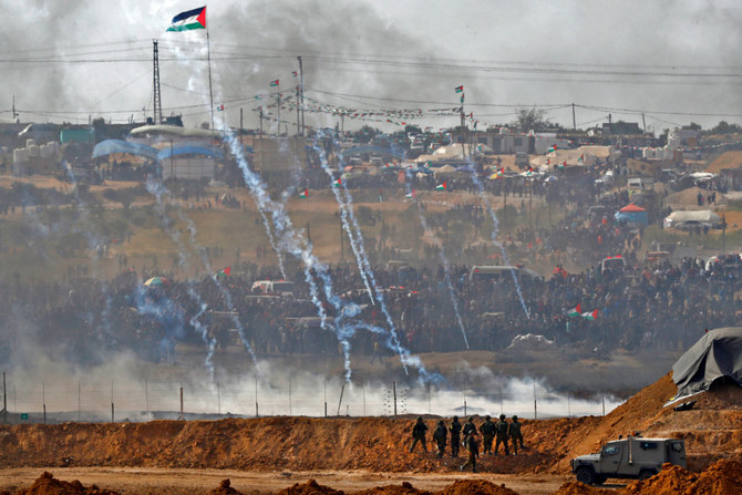 In this picture taken on April 13, 2018, Israeli soldiers keeping position in the southern kibbutz of Nahal Oz across the border with the Gaza Strip as Palestinian protesters gather along the border fence. Hamas militants easily defeated the high-tech wall in a massive attack on Oct. 7. (AFP/File)