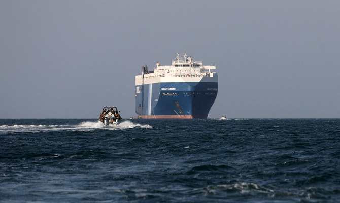 A boat carrying people sails near the Galaxy Leader commercial ship, seized by Yemen's Houthis last month, off the coast of Al-Salif, Yemen, December 5, 2023. (Reuters)