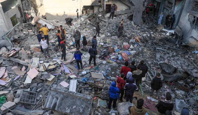 People gather amid the destruction following an early morning Israeli strike in Rafah in the southern Gaza Strip on December 9, 2023, amid continuing battles between Israel and the militant group Hamas. (AFP)