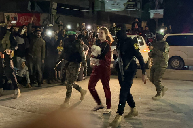 Hamas and Islamic Jihad fighters accompany a newly released Israeli hostage before handing her over to the Red Cross in Rafah, Gaza Strip, during a prisoner swap in Rafah,on November 28, 2023. (AFP/File)