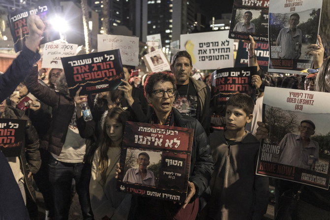 Yocheved Lifshitz (C), who was released by Hamas after 16 days in captivity, attends a protest with others holding signs showing portraits of other Israeli hostages held in Gaza since the October 7 attacks during a demonstration in Tel Aviv on December 9, 2023. (AFP/File)