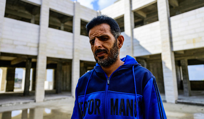 Palestinian construction worker Ibrahim al-Qiq poses in an unfinished school building, due to lack of funds, in the town of Kharas, north of Hebron in the occupied West Bank on December 6, 2023. (AFP)
