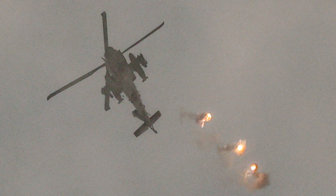 An Israeli air force attack helicopter releases flares while flying in an area along the border with the Gaza Strip and southern Israel on December 12, 2023 amid ongoing battles between Israel and the militant group Hamas. (AFP)