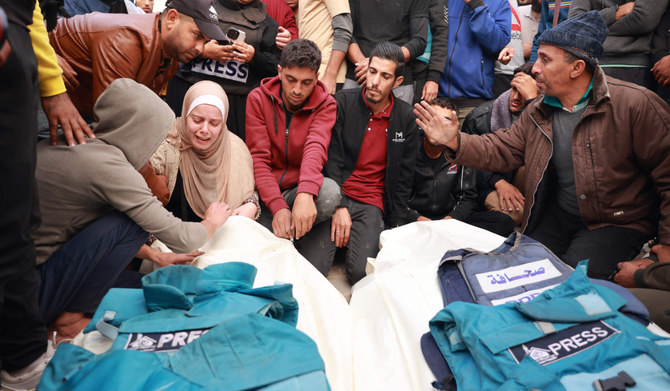 Relatives and colleagues of two Palestinian journalists Hasouna Slim and Sari Mansoor, killed in an Israeli strike, mourn over their bodies during their funeral in Deir al-Balah in the southern Gaza Strip on November 19, 2023. (AFP)