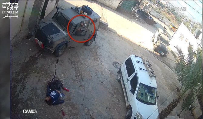An Israeli soldiers takes a picture of a Palestinian man he had just shot at close range during a raid in a West Bank refugee camp on Dec. 8, 2023. (Screen grab from video on X: @btselem)