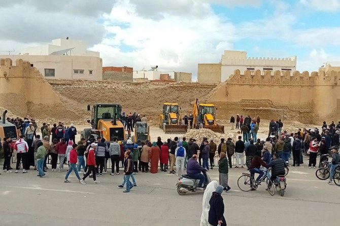 People and Civil Protection members gather at the site of a collapsed section of the ancient wall surrounding historic Kairouan in central Tunisia, killing three workers, on Dec. 16, 2023. (AFP)