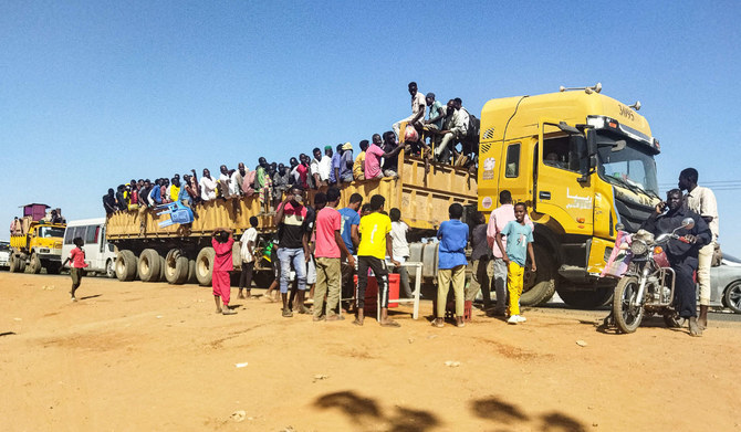 People displaced by the conflict in Sudan get on top of the back of a truck moving along a road in Wad Madani, the capital of al-Jazirah state, on December 16, 2023. (AFP)