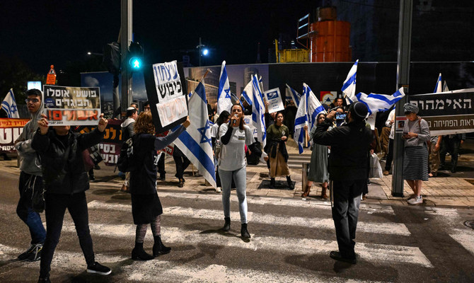 Israeli right wing protesters demonstrate near the Defense Ministry in Tel Aviv on December 16, 2023, close to another demonstration of friends and relatives of Israeli hostages held in Gaza since the October 7 attack. (AFP)