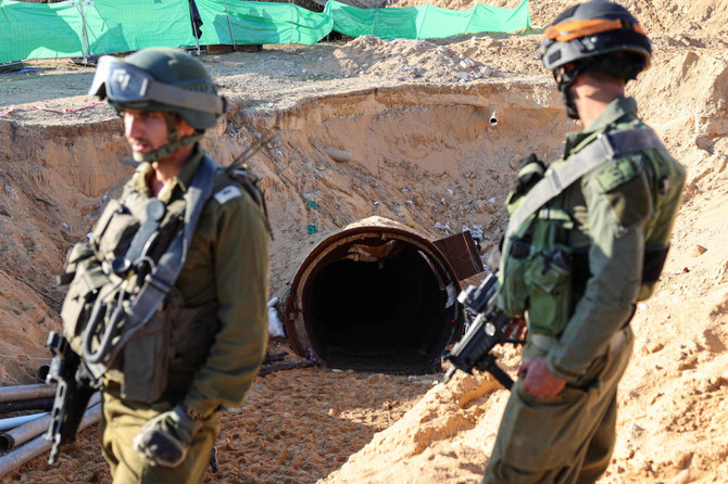 In this picture taken during a media tour organized by the Israeli military on December 15, 2023, soldiers stand at the entrance of a tunnel that Hamas reportedly used to attack Israel through the Erez border crossing on October 7. (AFP)