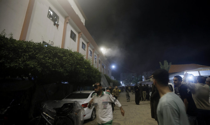 Palestinians look at smoke raising from the patient rooms following Israeli strikes on the maternity ward at Nasser Hospital in the town of Khan Younis, southern Gaza Strip, Sunday, Dec. 17, 2023. (AP)