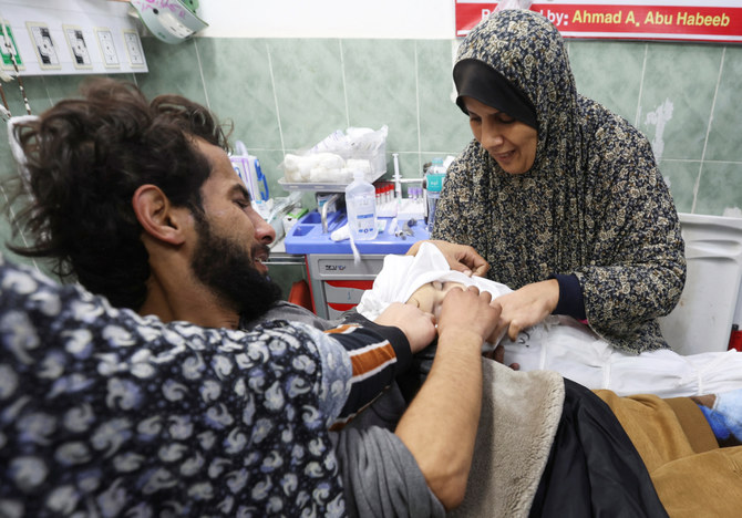 Suzan Zourob, the grandmother of two Palestinian children, a newborn Al-Amera Ayesha and a young boy Ahmed Zourob, who were killed in an Israeli strike, amid the ongoing conflict between Israel and the Palestinian Islamist group Hamas, mourns next to the children's wounded father, in Rafah, in the southern Gaza Strip, December 19, 2023. (REUTERS)