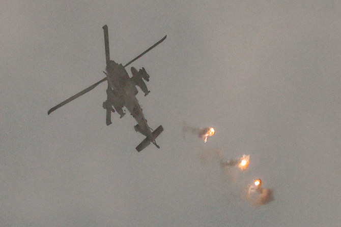 An Israeli air force attack helicopter releases flares while flying in an area along the border with the Gaza Strip and southern Israel on December 12, 2023 amid ongoing battles between Israel and the militant group Hamas. (AFP)