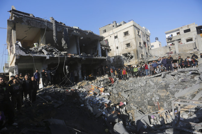 Palestinians watch the destruction after the Israeli bombardment of the Gaza Strip outside a morgue in Rafah, Tuesday, Dec. 19, 2023. (AP)