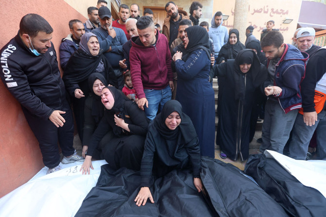 People mourn over the bodies of relatives, killed in Israeli bombardment, at Nasser hospital in Khan Yunis in the southern Gaza Strip on December 20, 2023. (AFP)