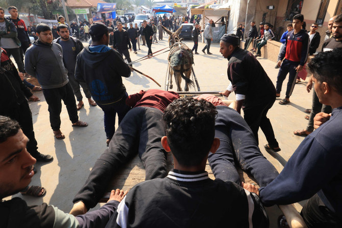 Palestinians use a donkey-drawn cart to transport bodies of victims of Israeli bombardment to Nasser hospital in Khan Yunis in the southern Gaza Strip on December 17, 2023. (AFP)