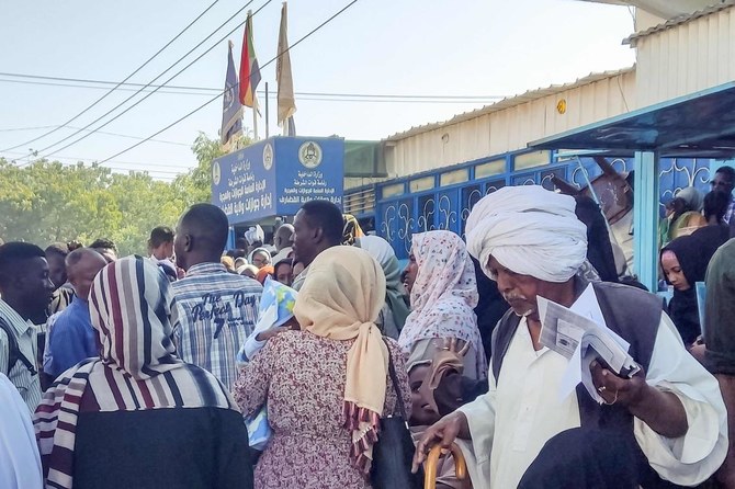 People displaced by the conflict in Sudan gather outside a passport office in the city of Gedaref as they attempt to get passports and exit visas after fleeing flee Wad Madani, the capital of Al-Jazirah state (AFP)