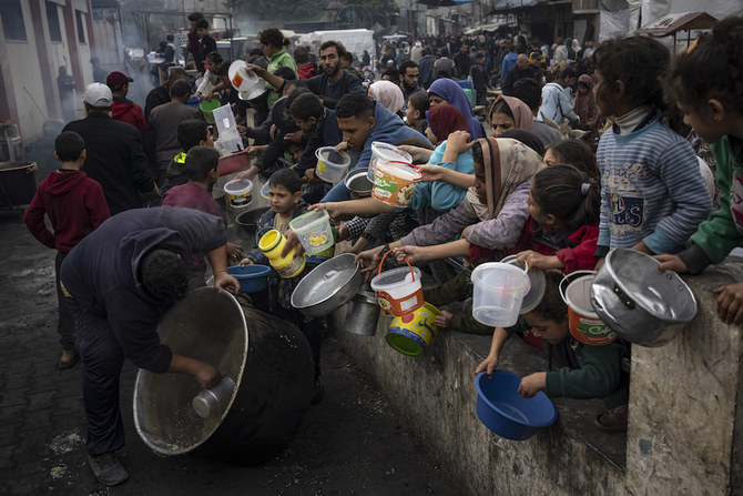 Palestinians line up for a free meal in Rafah, Gaza Strip, Thursday, Dec. 21, 2023. International aid agencies say Gaza is suffering from shortages of food, medicine and other basic supplies as a result of the two and a half month war between Israel and Hamas. (AP)