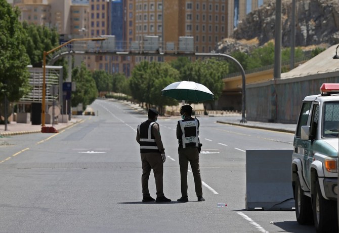 Police officers man a checkpoint in a street in Saudi Arabia's holy city of Mecca on April 3, 2020. (AFP)