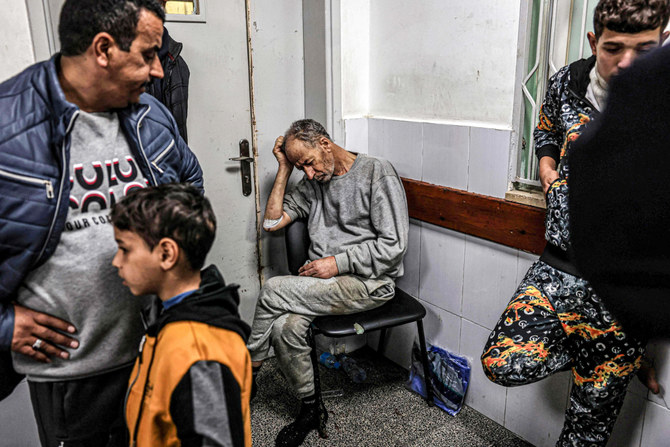 A man, who was detained with other Palestinians by the Israeli military during their operation in the northern Gaza Strip and recently released through the Kerem Shalom crossing, reacts as he awaits treatment for his injuries at al-Najjar hospital in Rafah in the southern Gaza Strip on December 24, 2023, amid the ongoing conflict between Israel and the Palestinian militant group Hamas. (AFP)