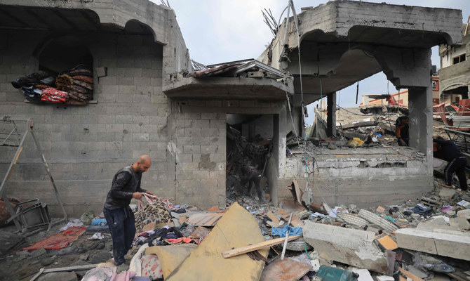 Palestinians inspect the damage at the Al-Maghazi refugee camp after an overnight Israeli strike on December 25, 2023, amid ongoing battles between Israel and the Palestinian militant group Hamas. (AFP)