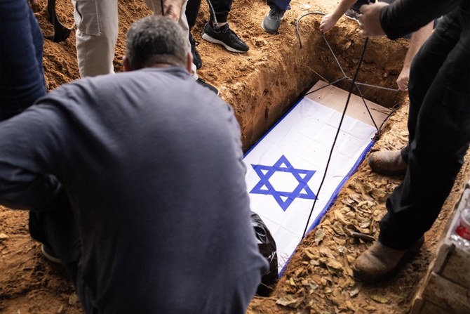The body of Alon Shamriz, mistakenly killed by Israeli forces in Gaza, is lowered into the grave during the funeral in kibbutz Shefayim near Tel Aviv. (AFP)