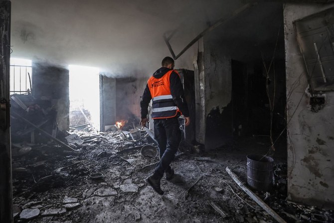 Above, a man walks in a burnt house on Dec. 13, 2023, which was damaged the night before during an Israeli army raid in Jenin in the occupied West Bank. (AFP)