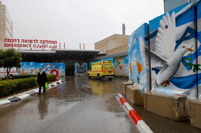 A man walks past murals outside the Ziv Hospital in the northern Israeli city of Safed as fighting continues between Israel and the Palestinian militant group Hamas in Gaza. (File/AFP)