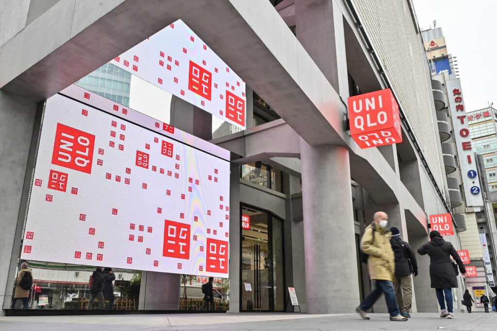 Pedestrians walk past a branch of the Fast Retailing clothing brand Uniqlo along a street in Tokyo on January 11, 2024. (AFP)