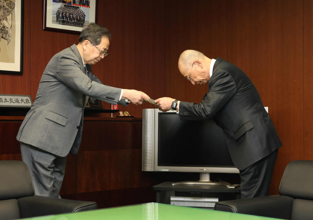 Daihatsu Motor President Soichiro Okudaira (R) receives an improvement order from Japan's Minister of Land, Infrastructure, Transport and Tourism Tetsuo Saito at the ministry in Tokyo on Jan. 16, regarding the certification exam fraud issue. (AFP)