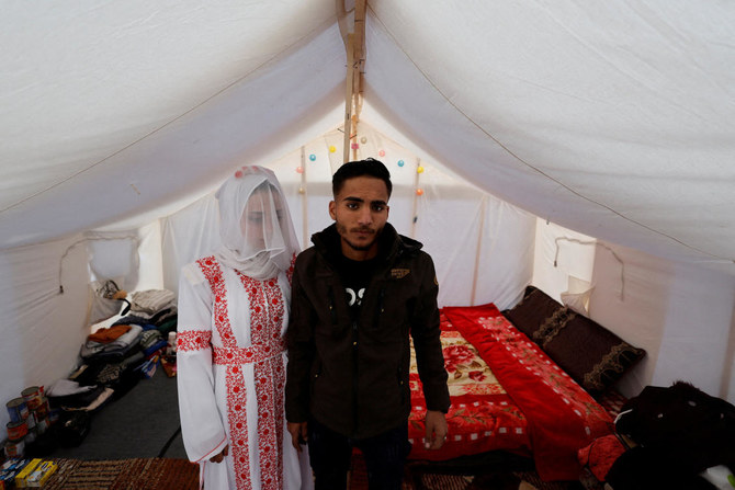 A Palestinian couple, Mohammed Al-Ghandour and his bride Shahad, stands in a tent camp, amid the ongoing conflict between Israel and Hamas on their wedding day, in Rafah on Jan. 18, 2024. (Reuters)
