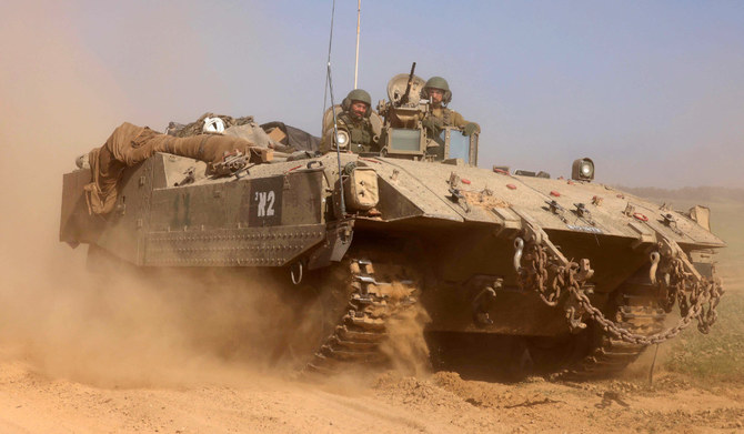 This photograph taken near the border with the Gaza Strip shows Israeli soldiers on an armoured personnel carrier (APC) rolling back from the Gaza Strip, on December 31, 2023 amid continuing battles between Israel and the militant group Hamas. (AFP)