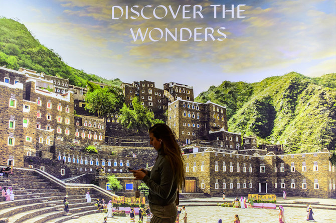A visitor walks past a billboard at the Saudi Arabia stand at the International Tourism Trade Fair in Berlin on March 8, 2023. (AFP)